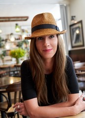 Happy woman in hat sitting in cafe restaurant