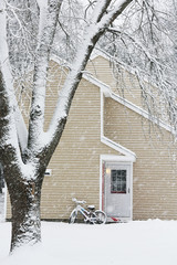 a small cozy house covered with snow during the snowfall. The atmosphere of winter comfort and weather.