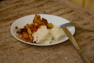rice and vegetable stew with chicken meat on a white plate. Home cooked food. Asian recipes