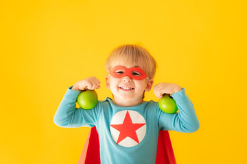 Superhero child holding apple