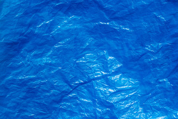 Texture of crumpled blue plastic trash bag. Abstract background for design.