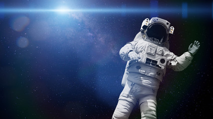 Obraz na płótnie Canvas spacewalking astronaut lit by the Sun