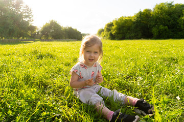 Large rural lawn and sitting little girl on it