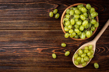 Green grape on dark wooden background.