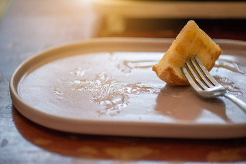 Butter baked bread topped with delicious milk and sugar by using a fork to eat until the last piece in retro coffee shop.