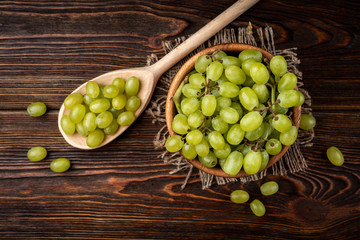 Green grape on dark wooden background.