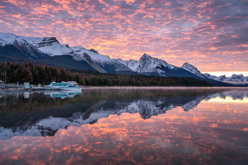 Canadian rockies with commercial dock and colorful altocumulus clouds reflections on Maligne lake - obrazy, fototapety, plakaty