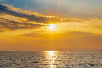 Naklejka na ściany i meble landscape of sunset on the coast sea, waves, horizon. top view.