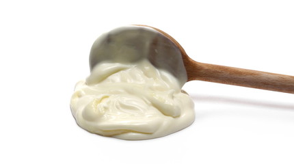 Mayonnaise puddle with wooden spoon isolated on white background