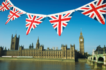 Fototapeta na wymiar Traditional British Union Jack flag bunting hanging in front of the Westminster Palace in blue sky in London, UK