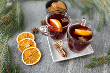 christmas and seasonal drinks concept - hot mulled wine, dry orange slices, gingerbread and...