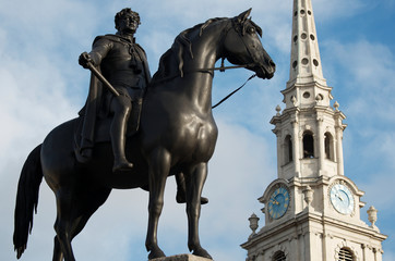 Equestrian statue of King George IV, cast in 1828, standing in front of the steeple of St Martin-in-the-Fields church in Trafalgar Square, London, UK