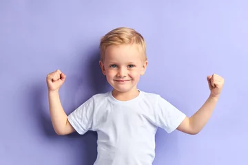 Fototapeten Winner kid isolated over purple background, show how powerful he is. Isolated over purple background © alfa27