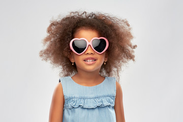 childhood, summer accessory and valentines day concept - happy little african american girl in...
