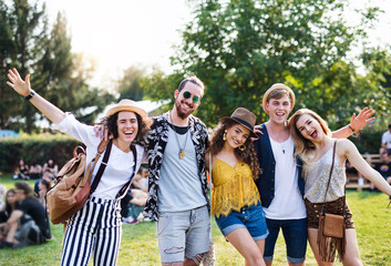 Group of young friends at summer festival. - obrazy, fototapety, plakaty