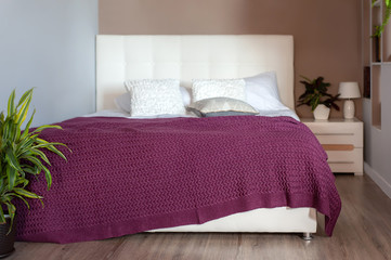 Marsala color knit blanket on bed in cozy bedroom
