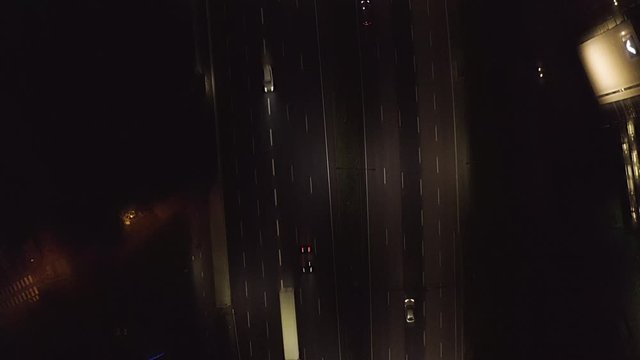 Aerial, top down, drone shot, over traffic, on highway Keha 1, on a dark, autumn night, in Helsinki, Finland