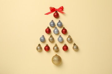 Christmas tree made of baubles on beige background, space for text