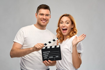 production, filmmaking and entertainment concept - portrait of happy couple in white t-shirts with...