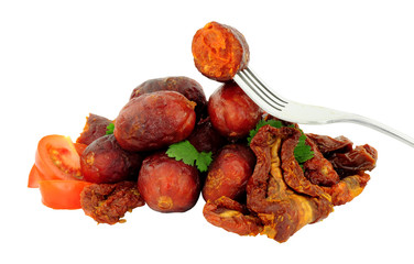 Group of spicy chorizo meatballs with sun dried and fresh tomatoes isolated on a white background