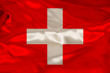 photo of beautiful colored national flag of modern state of Switzerland on textured fabric, concept of tourism, emigration, economy and politics, closeup
