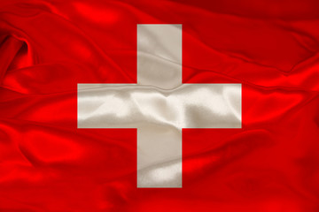 photo of beautiful colored national flag of modern state of Switzerland on textured fabric, concept of tourism, emigration, economy and politics, closeup