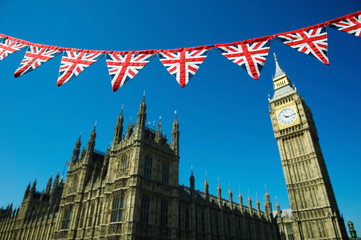 Fototapeta na wymiar Vintage British Union Jack flag bunting hanging in front of the Houses of Parliament at Westminster on a bright sunny day in London, UK