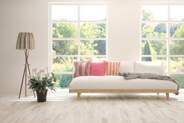 Stylish room in white color with sofa and summer landscape in window. Scandinavian interior design. 3D illustration