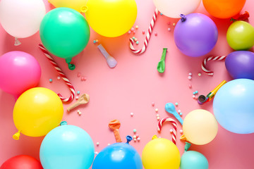 Frame made of balloons and party decor on color background