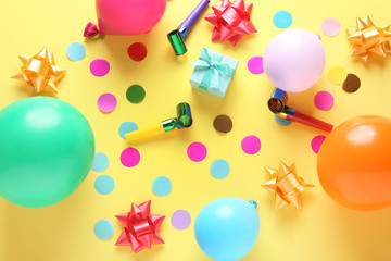 Balloons and party decor on color background