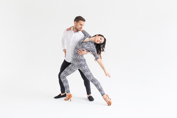 Social dance, bachata, kizomba, zouk, tango concept - Man hugs woman while dancing over white...