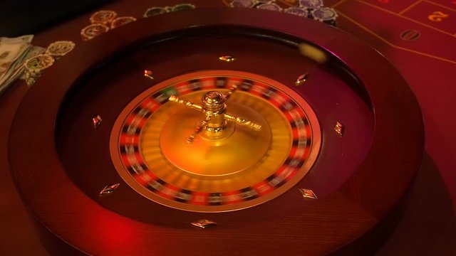 Casino roulette in motion with spinning wheel and ball. The croupier throws the ball at a spinning roulette. Winning number 8 and color Black is determined by the roulette wheel. Roulette table layout