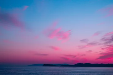 Poster Beautiful pink sunset on the sea with blue sky © Ivan