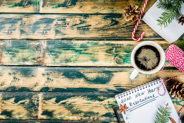 New year Resolution Concept - 2020 number and text in notepad. Coffee cup, Christmas decoration and pen for writing, Old wooden background copy space