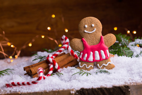 Cute smiling gingerbread man or woman with cinnamon sticks in snow landscape - Christmas background - Greeting card - Xmas card - Advent time