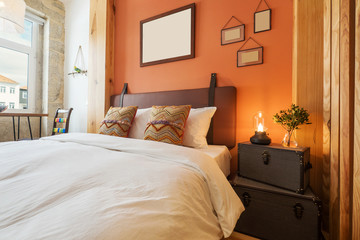 Light modern interior design, studio apartment with double bed, big windows and wooden decor. Orange and white color wall