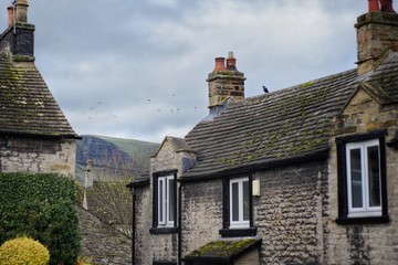 Rooftops of Castleton, Peak District, UK looking towards Mam Tor paragliders