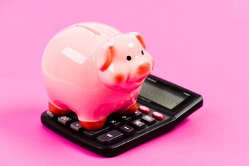 Exchange rates. Economics and business administration. Piggy bank money savings. Piggy bank pink pig and calculator. Credit debt concept. Economics and profit management. Economics and finance