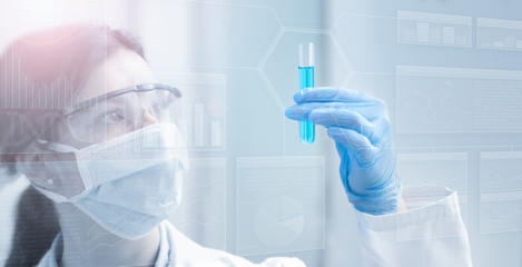 woman chemist holding a test tube in light blue background - obrazy, fototapety, plakaty