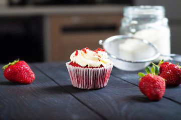 Red velvet cake with whipped cream and fresh strawberries on black wooden background. Closeup