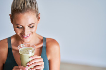 Adult woman drinking healthy smoothie after workout - obrazy, fototapety, plakaty