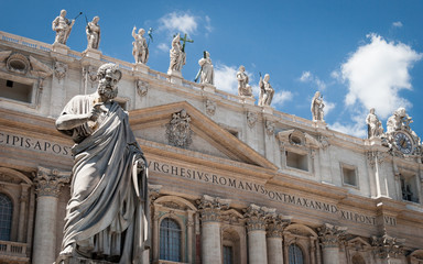 St. Peter, Vatican City. Low angle view of the statue of St. Peter in St. Peter's Square, Vatican City, with the façade of the Basilica behind.
