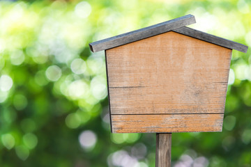 Wooden sign on natural green bokeh background