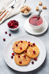 Fototapeta na wymiar Cottage cheese pancakes with cranberries. Russian syrniki or sirniki, cottage cheese fritters or pancakes on the plate.