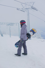 Young snowboarder riding in the mountains on a snowboard.