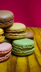 Colored macarons isolated on wooden dish, typical French dish