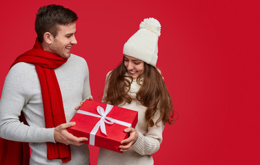 Happy man giving Christmas present to girlfriend