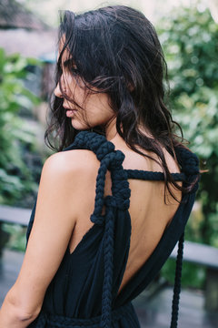 Outdoor Portrait of Beautiful woman with long hair. Shoulder and back close up view, black cotton dress unusual design