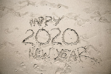 Inscription on the sand Happy New year 2020. Concept of new year. Toned image in brown