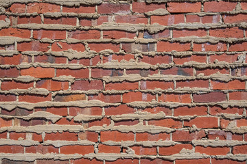 Retro red brick wall with cement filling oozing out